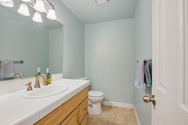 bathroom with toilet, vanity, baseboards, and tile patterned flooring