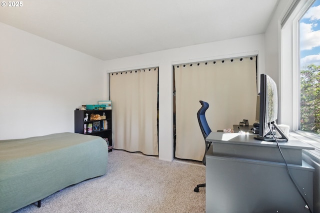 carpeted bedroom featuring a desk