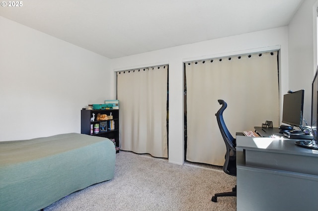 carpeted bedroom with a desk