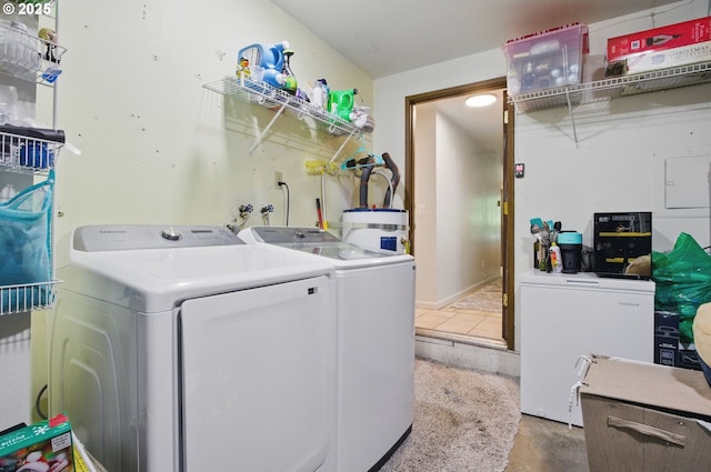 laundry room featuring water heater and washing machine and clothes dryer