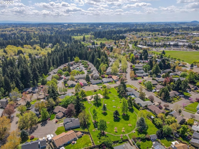 aerial view of property's location with a heavily wooded area and nearby suburban area