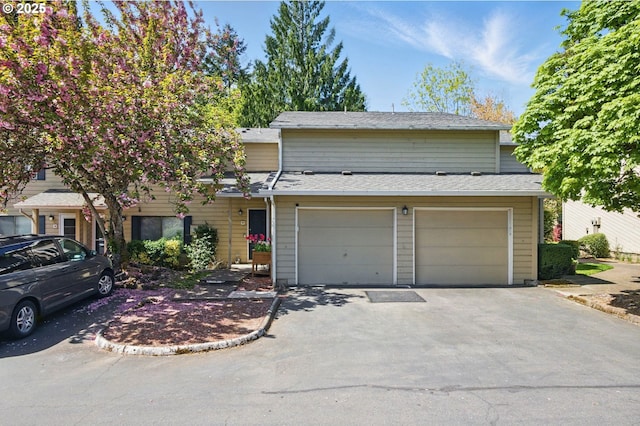 multi unit property with asphalt driveway and a garage