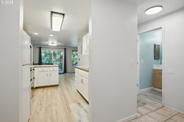 corridor with light wood-type flooring and baseboards