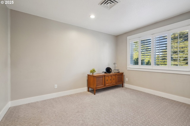 empty room with recessed lighting, visible vents, light carpet, and baseboards