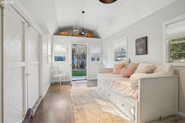 bedroom with vaulted ceiling, access to outside, wood finished floors, and baseboards