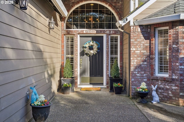 doorway to property featuring brick siding