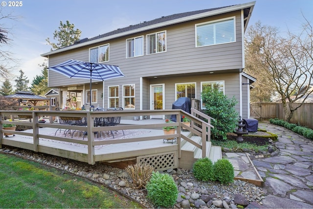 back of house featuring fence and a deck