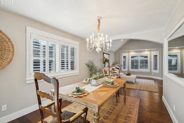 dining area with vaulted ceiling, dark wood-style flooring, a notable chandelier, and baseboards