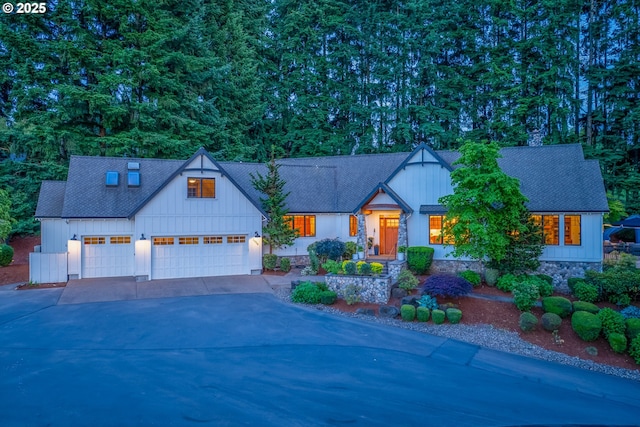 20754 SW Prindle Rd, Tualatin, OR 97062 - view of front of home featuring board and batten siding, driveway, an attached garage, stone siding, and roof with shingles