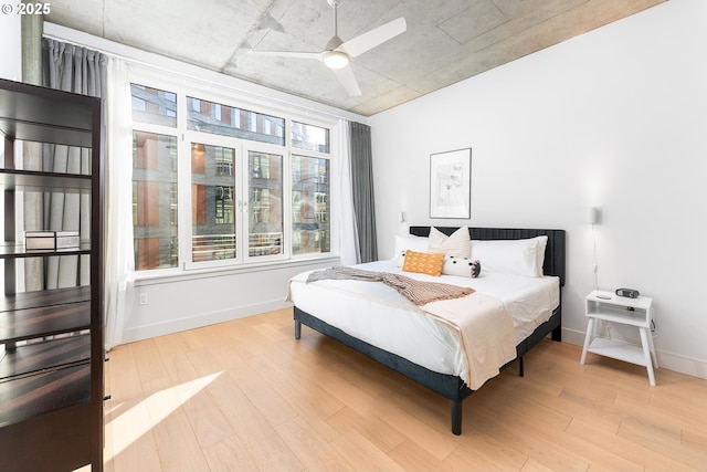 bedroom featuring light wood-style floors, ceiling fan, and baseboards