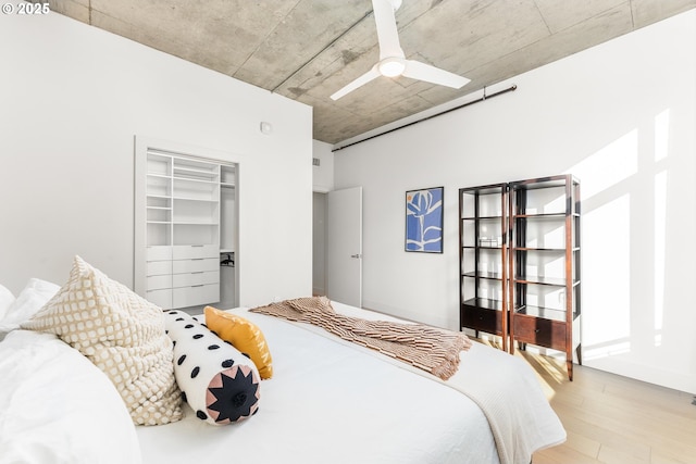 bedroom with a closet, ceiling fan, and light wood finished floors