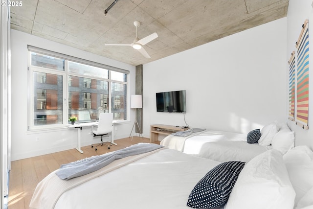 1255 NW 9th Ave Unit 411, Portland, OR 97209 - bedroom with wood finished floors, a ceiling fan, and a desk