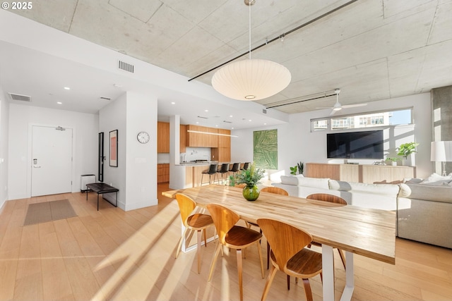 dining space with light wood-style flooring and visible vents