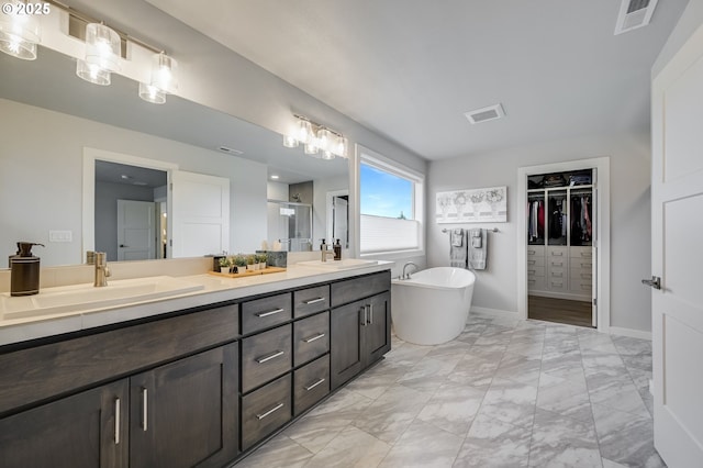 2511 S White Salmon Dr, Ridgefield, WA 98642 - bathroom with double vanity, marble look tile flooring, a walk in closet, a soaking tub, and a stall shower