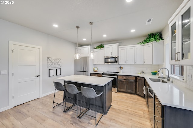 2511 S White Salmon Dr, Ridgefield, WA 98642 - kitchen with stainless steel appliances, a kitchen breakfast bar, light wood-style floors, a center island, and recessed lighting