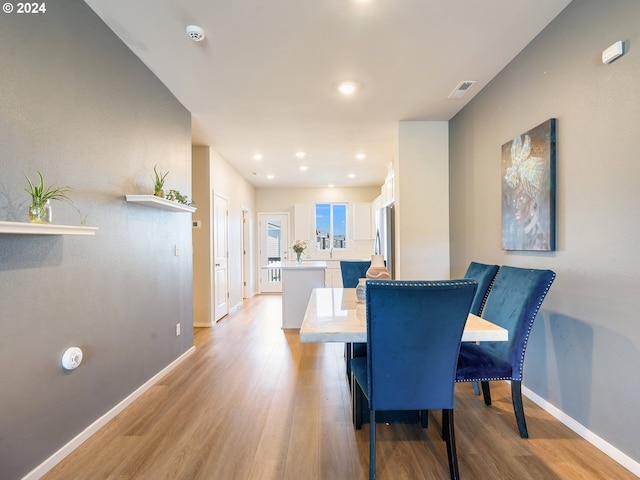 dining room with recessed lighting, baseboards, visible vents, and light wood finished floors