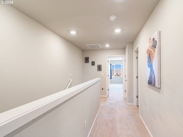 hallway with recessed lighting, light colored carpet, visible vents, an upstairs landing, and baseboards