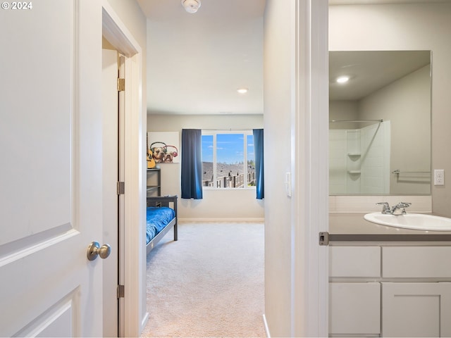 bathroom featuring walk in shower, vanity, and baseboards