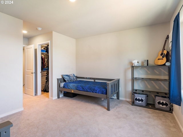 bedroom with carpet floors, a spacious closet, baseboards, and a closet