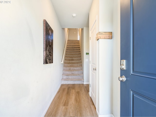 corridor featuring stairway, wood finished floors, and baseboards