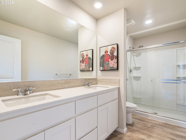 full bathroom featuring a shower stall, a sink, and wood finished floors