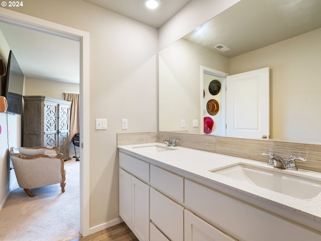 full bathroom featuring visible vents, a sink, baseboards, and double vanity