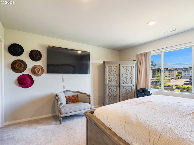 carpeted bedroom featuring baseboards and visible vents