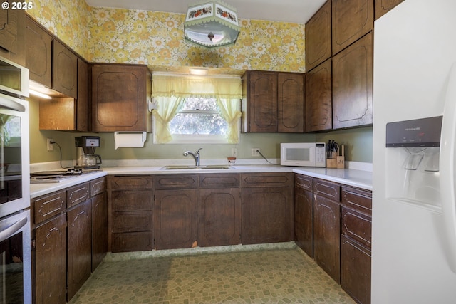 48025 NW Strohmayer Rd, Forest Grove, OR 97116 - kitchen featuring stainless steel appliances, a sink, light countertops, and wallpapered walls