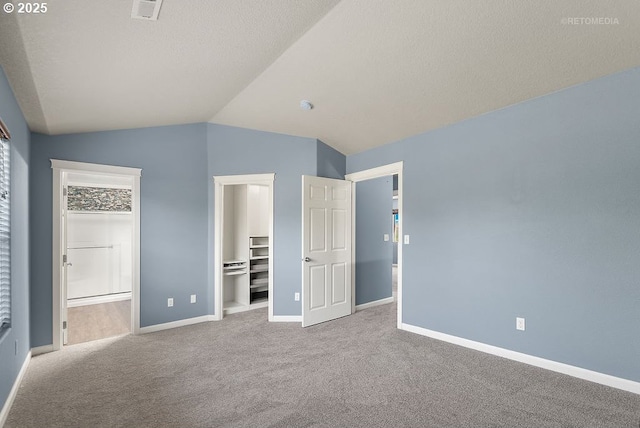 2820 23rd Pl, Forest Grove, OR 97116 - unfurnished bedroom with a walk in closet, carpet, vaulted ceiling, baseboards, and a closet