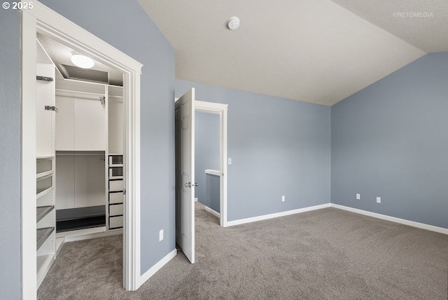 2820 23rd Pl, Forest Grove, OR 97116 - unfurnished bedroom featuring carpet flooring, a closet, vaulted ceiling, baseboards, and a walk in closet