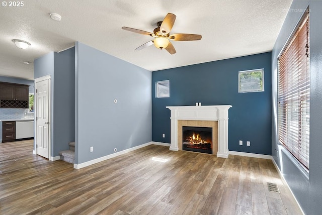 2820 23rd Pl, Forest Grove, OR 97116 - unfurnished living room featuring ceiling fan, a fireplace, wood finished floors, a textured ceiling, and stairs