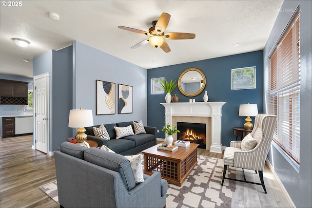 2820 23rd Pl, Forest Grove, OR 97116 - living area with light wood-style flooring, a tile fireplace, ceiling fan, and a textured ceiling