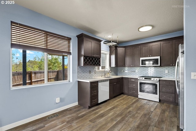 2820 23rd Pl, Forest Grove, OR 97116 - kitchen with appliances with stainless steel finishes, dark brown cabinetry, dark wood finished floors, and tasteful backsplash