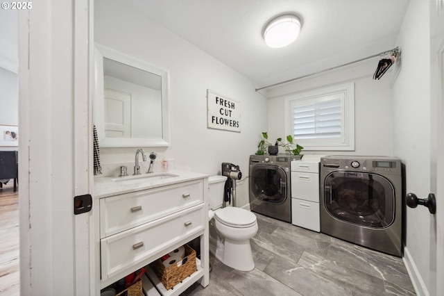 bathroom featuring washer and clothes dryer, toilet, and vanity