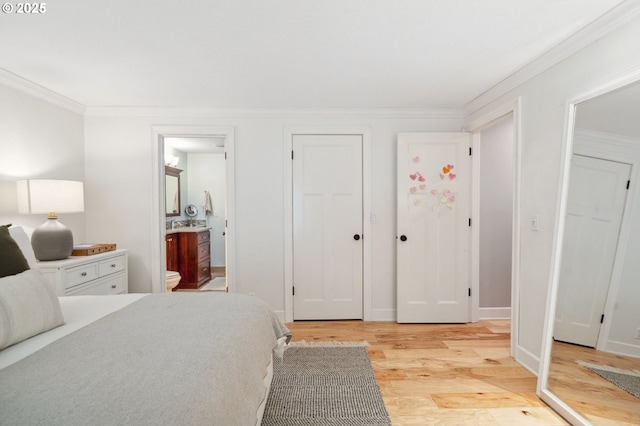bedroom with light wood-style floors, crown molding, and ensuite bath
