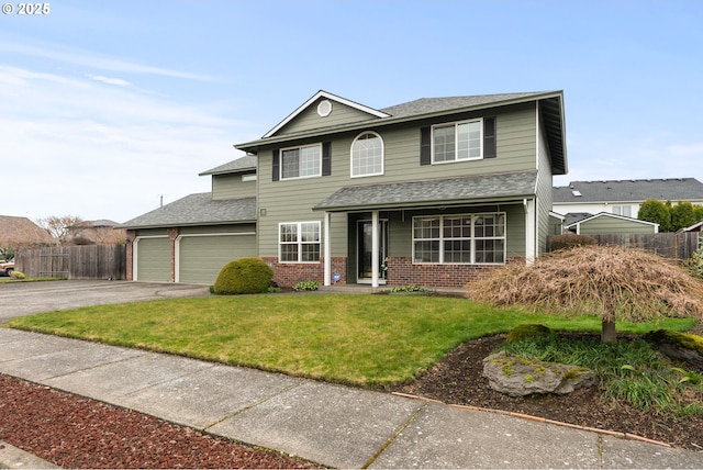 traditional home featuring a front yard, fence, driveway, a garage, and brick siding