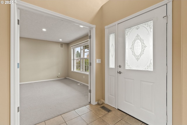 entryway featuring visible vents, light carpet, recessed lighting, light tile patterned floors, and baseboards