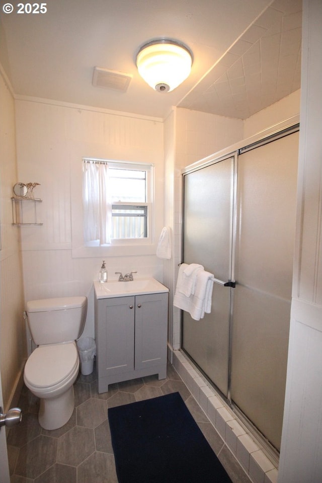 bathroom featuring tile patterned floors, vanity, toilet, and an enclosed shower