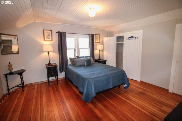 bedroom with lofted ceiling, dark hardwood / wood-style flooring, and wooden ceiling