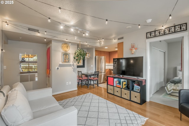 living area with visible vents and light wood-style floors