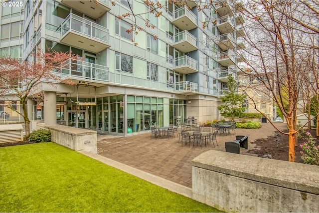 view of home's community featuring a patio and a lawn