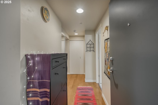 hallway with baseboards and light wood-style flooring