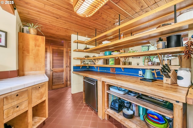 2696 Moon Mountain Dr, Eugene, OR 97403 - kitchen with open shelves, dark tile patterned flooring, wood ceiling, tile countertops, and dishwasher