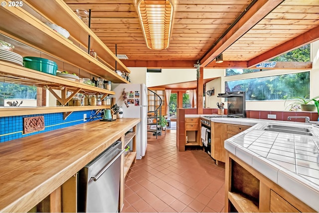 2696 Moon Mountain Dr, Eugene, OR 97403 - kitchen featuring tile countertops, open shelves, freestanding refrigerator, dishwasher, and a wooden ceiling with exposed beams