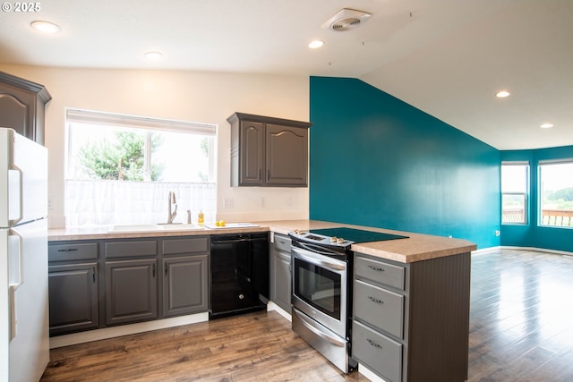 906 N Railroad Ave, Ridgefield, WA 98642 - kitchen featuring black dishwasher, stainless steel range with electric stovetop, freestanding refrigerator, gray cabinetry, and vaulted ceiling