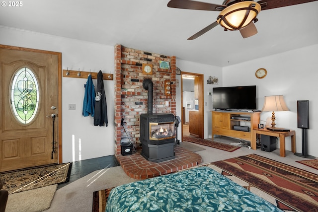 878 NW Warrenton Dr, Warrenton, OR 97146 - carpeted living room featuring a wood stove and a ceiling fan