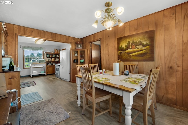 878 NW Warrenton Dr, Warrenton, OR 97146 - dining space with wooden walls, light wood-type flooring, and a chandelier