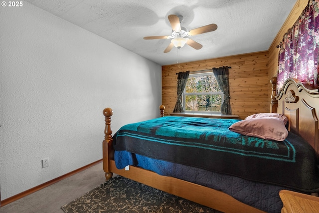 878 NW Warrenton Dr, Warrenton, OR 97146 - carpeted bedroom featuring a ceiling fan, a textured ceiling, wood walls, baseboards, and a textured wall