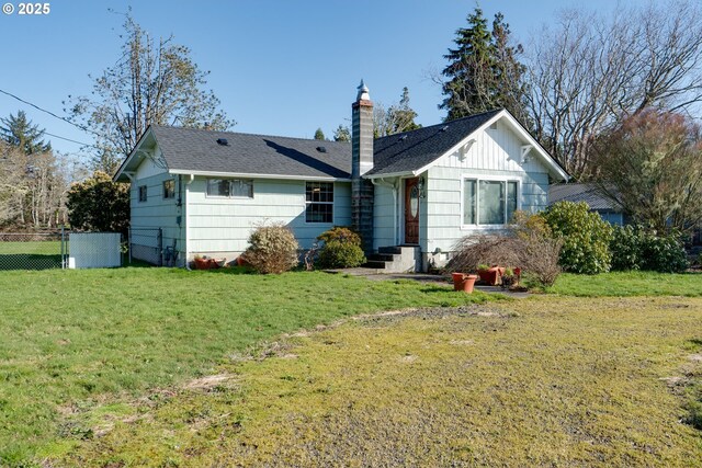878 NW Warrenton Dr, Warrenton, OR 97146 - back of property with a lawn, a shingled roof, a chimney, and fence