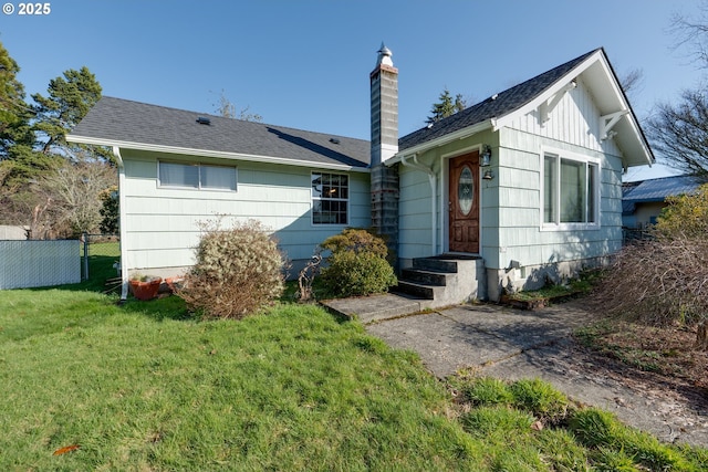 878 NW Warrenton Dr, Warrenton, OR 97146 - view of front of house featuring a chimney, roof with shingles, a front lawn, and fence